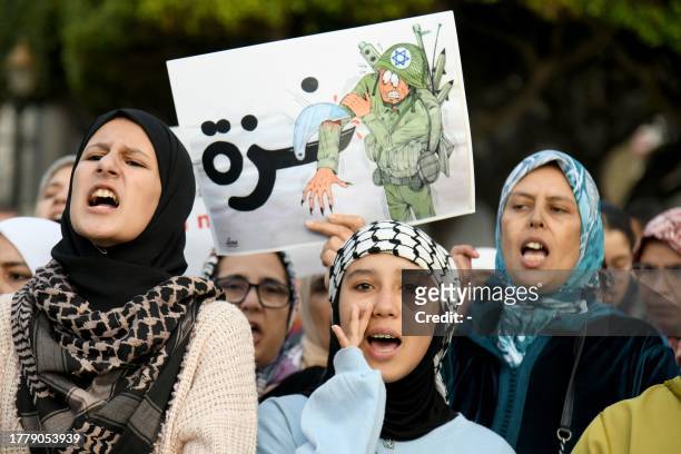 Young women shout slogans and hold a placard to show their support for the Palestinian people in the Israeli occupied West Bank and the Gaza Strip,...
