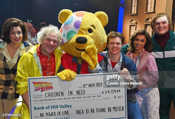 Pudsey poses with cast members Sarah Goggin, Lee Ormsby, Ben Joyce, Sophie Naglik and Jordan Pearson backstage at the Back To The Future x BBC Radio...