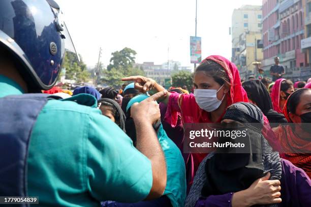 Police try to convince garment industry workers to leave the streets, as they continue to protest on the street demanding a wage raise, at Mirpur...