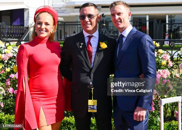 Jockey Zac Purton poses with Frankie Dettori and wife Nicole Purton during Melbourne Cup Day at Flemington Racecourse on November 07, 2023 in...