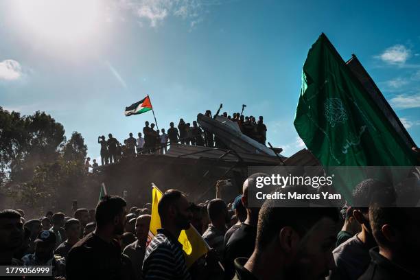 Cacophony of thunderous gunfire & sorrowful praise to the Almighty punctuate a mass funeral for 14 Palestinians killed after Israeli forces raided...