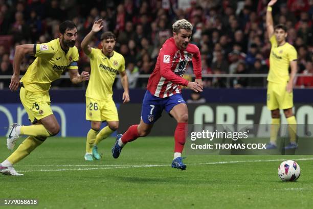 Atletico Madrid's French forward Antoine Griezmann is challenged by Villarreal's Spanish defender Raul Albiol during the Spanish league football...