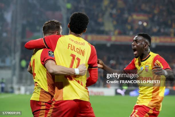 Lens' French defender Jonathan Gradit is congratulated by teammates after scoring a goal during the French L1 football match between RC Lens and...