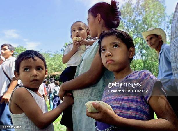 Gloria Orellana with her daughter Brenda , three year old son Juan , and seven year old daughter Jesica , stands in line to receive food rations on...