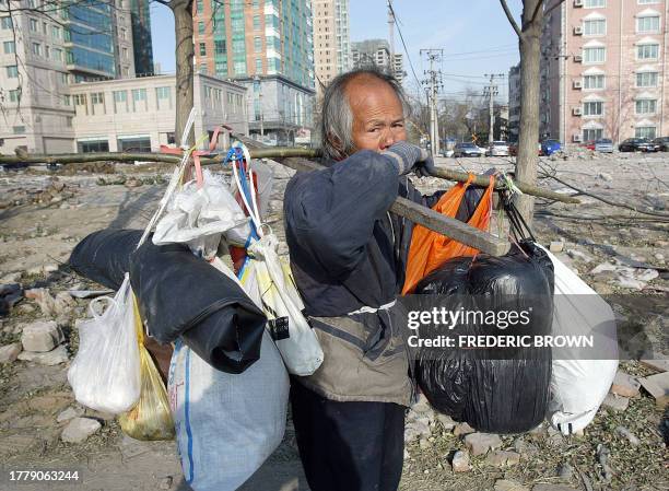 Homeless man walks alone trough a razed Beijing neighborhood, 18 January 2004. Many of China's growing number of elderly people are forced to spend...