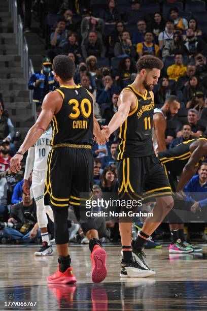 Stephen Curry and Klay Thompson of the Golden State Warriors high five during the game against the Minnesota Timberwolves on November 12, 2023 at...