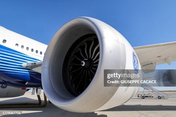 This picture taken on November 13, 2023 shows a view of one of the General Electric-built engines of a Boeing 777-9 jetliner aircraft on the tarmac...