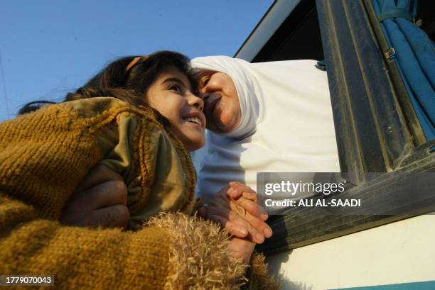 Grandmother kisses her granddaughter goodbye as she leans out of the window of a bus leaving for the Hajj in the holy city of Mecca in Saudi Arabia,...