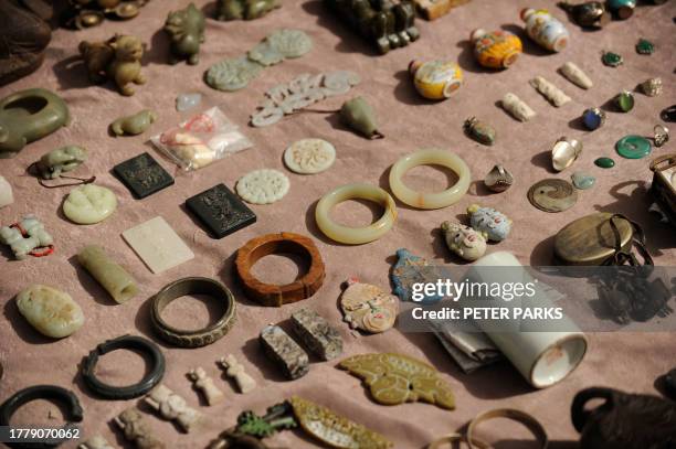 Jade and wood trinkets are on sale at Panjiayuan flea market in Beijing on March 20, 2010 where you can buy anything from Ming Dynasty pottery and...