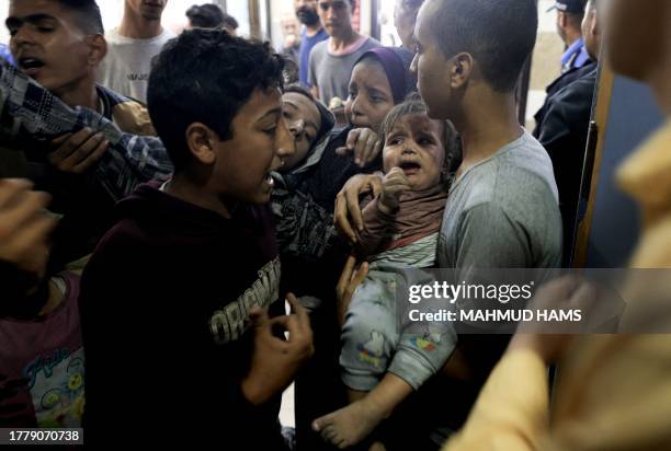 Graphic content / TOPSHOT - A wounded Palestinian child and other members of the Baraka family arrive at Nasser Hospital in Khan Yunis, following...