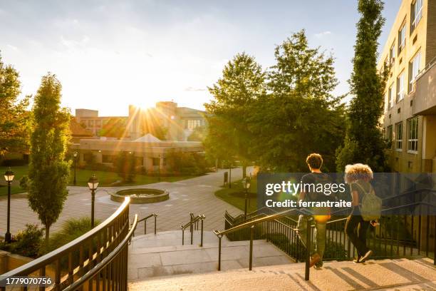 dos estudiantes universitarios bajan las escaleras del campus - estudiante fotografías e imágenes de stock