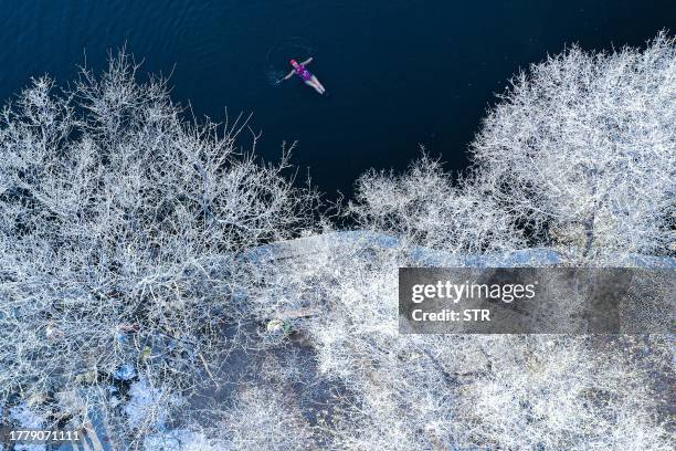 This photo taken on November 12, 2023 shows a winter swimming enthusiast braving the cold temperatures as she swims at Beiling Park in Shenyang, in...