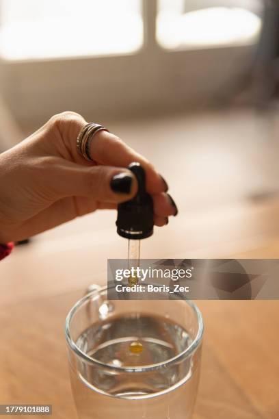 close-up of an unrecognizable woman using and holding medical cannabis oil - stock photo - cannabis concentrate stock pictures, royalty-free photos & images