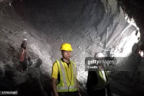 This handout photo taken on November 13 and released by the State Disaster Response Force shows rescue workers at the site after a tunnel collapsed...