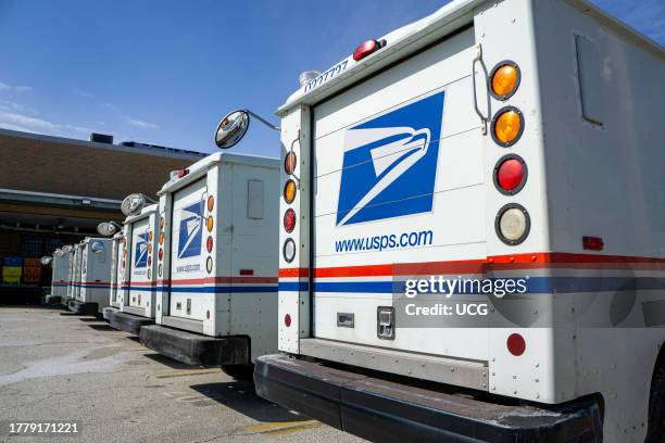 Row of USPS delivery trucks.