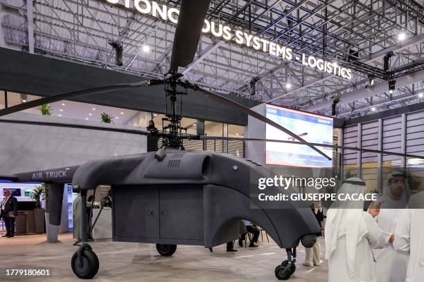 People stand near an ADASI Air Truck unmanned aerial system with a 500 kilogramme payload capacity at the EDGE pavilion during the 2023 Dubai Airshow...