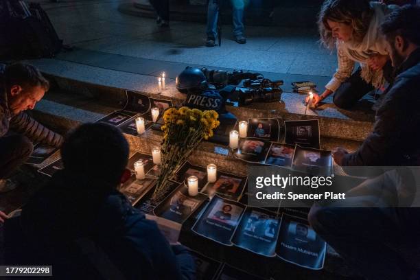 Members of the media and others gather for a vigil in lower Manhattan on November 6, 2023 in New York City. The vigil is held to remember and...