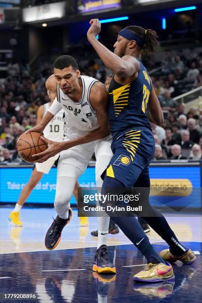 Victor Wembanyama of the San Antonio Spurs dribbles the ball while being guarded by Myles Turner of the Indiana Pacers in the first quarter at...