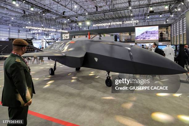 Military officer views a Jeniah unmanned combat aerial vehicle with stealth characteristics at the EDGE pavilion during the 2023 Dubai Airshow at...