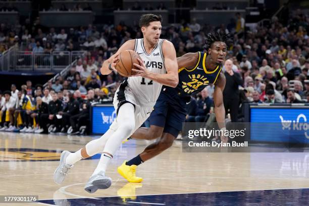 Doug McDermott of the San Antonio Spurs dribbles the ball while being guarded by Aaron Nesmith of the Indiana Pacers in the first quarter at...