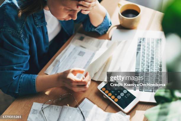 woman accountant use calculator and computer with holding pen on - banking document stock-fotos und bilder