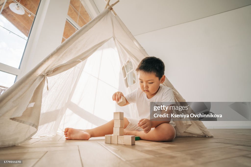 Asian boy playing dice in a tent