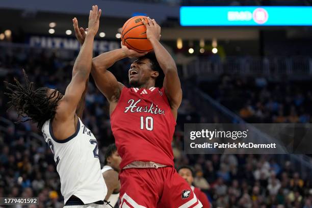 Zion Russell of the Northern Illinois Huskies is fouled by Sean Jones of the Marquette Golden Eagles in the second half at Fiserv Forum on November...