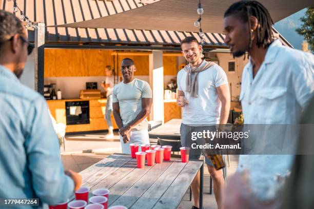 diverse friends compete in beer pong - beirut stockfoto's en -beelden