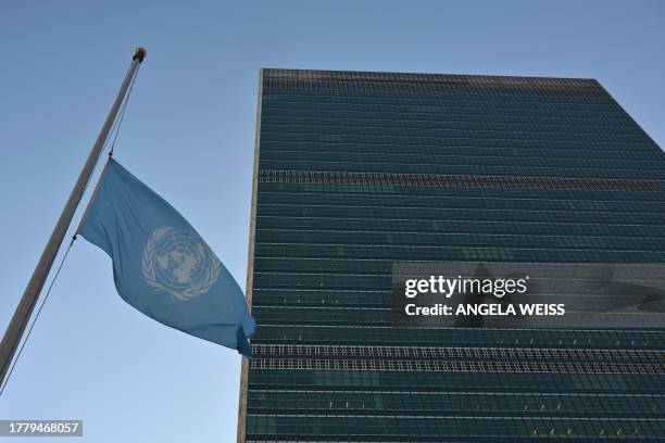 Flags fly at half-mast at the United Nations headquarters in New York on November 13, 2023 as staff observe a minute's silence in memory of...