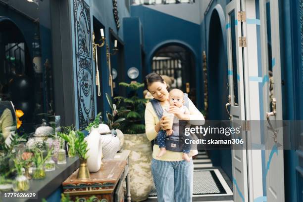 asian baby feeling negative emotion and crying and shouting with her mother embracing - baby pout stock pictures, royalty-free photos & images