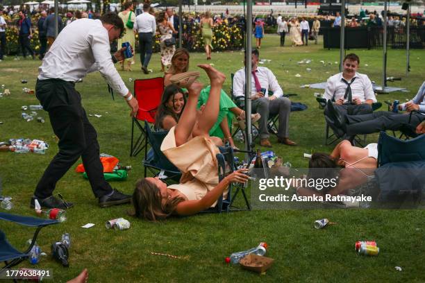 Racegoers falls over on her chair during Melbourne Cup Day at Flemington Racecourse on November 07, 2023 in Melbourne, Australia.