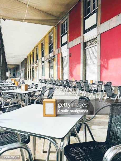 cafe tables and chairs on a street with arches - napkin holder stock pictures, royalty-free photos & images
