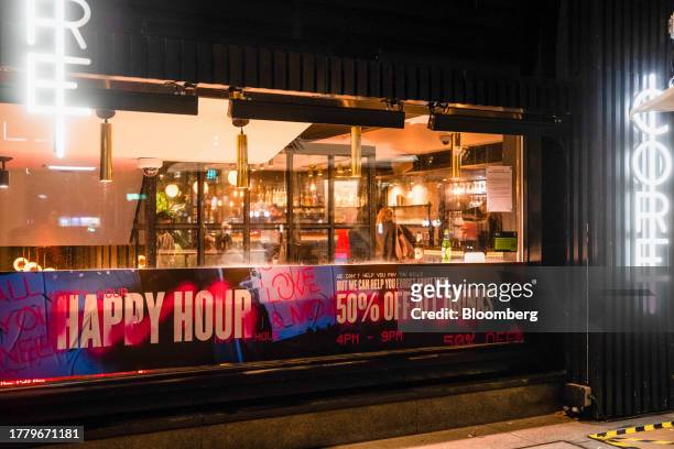 Happy Hour" promotion in the window Core bar in the City of London, UK, Tuesday, Nov. 7, 2023. City center pubs, still in recovery mode in the...