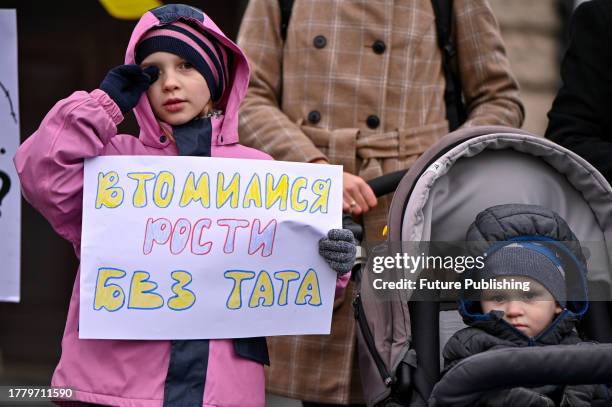 Girl holds a placard during a peaceful rally demanding the demobilization of soldiers after 18 months of service outside the Solomiia Krushelnytska...
