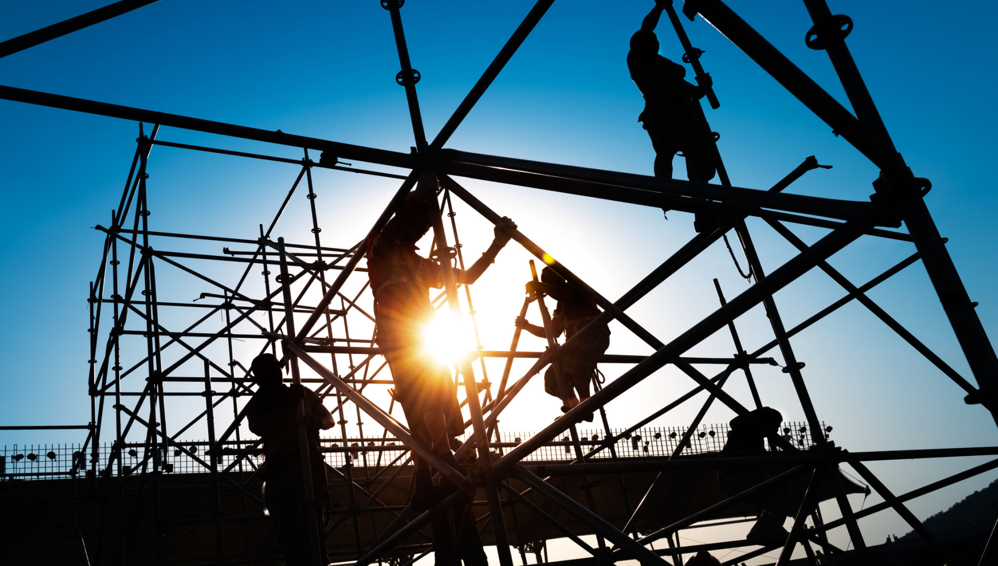 Group of construction workers working on scaffolding Group of construction workers working on scaffolding
