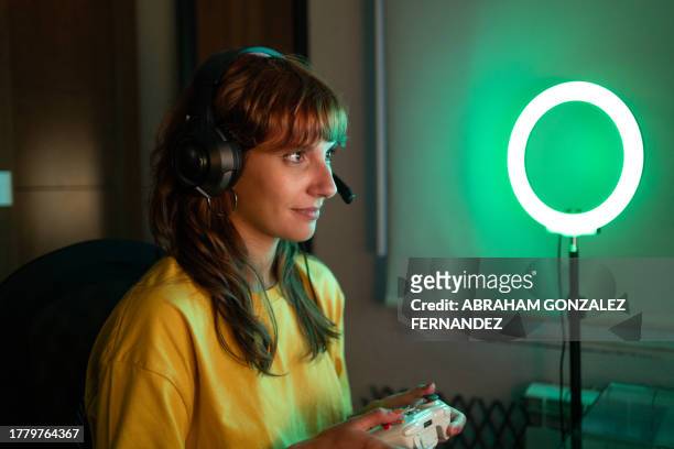 gamer playing using joystick and headphones in the room - adrenaline junkie stock pictures, royalty-free photos & images