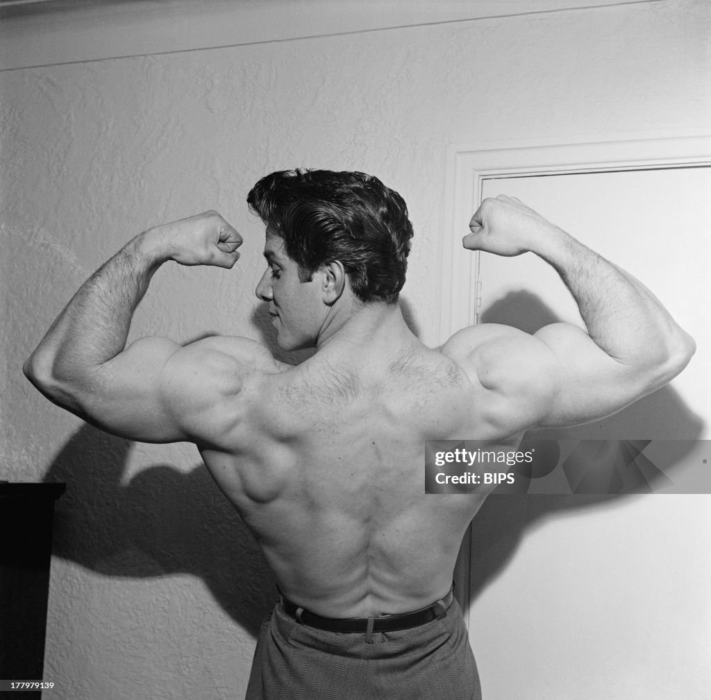 English bodybuilder Reg Park flexes his biceps, circa 1955. Park was