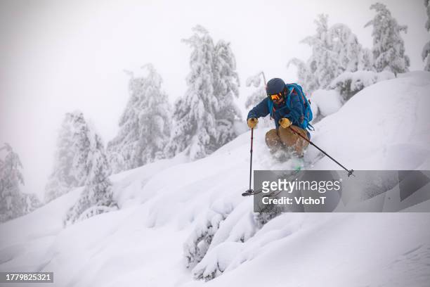 junger skitourengeher, der abseits der piste im tiefschnee unterwegs ist - skifahren und snowboarden stock-fotos und bilder