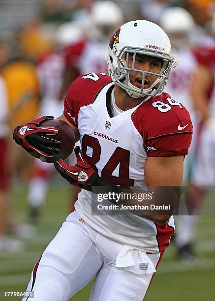 Rob Housler of the Arizona Cardinals participates in warm-ups before a game against the Green Bay Packers at Lambeau Field on August 9, 2013 in Green...