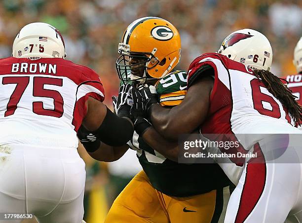 Raji of the Green Bay Packers rushes against Levi Brown and Jonathan Cooper of the Arizona Cardinals at Lambeau Field on August 9, 2013 in Green Bay,...