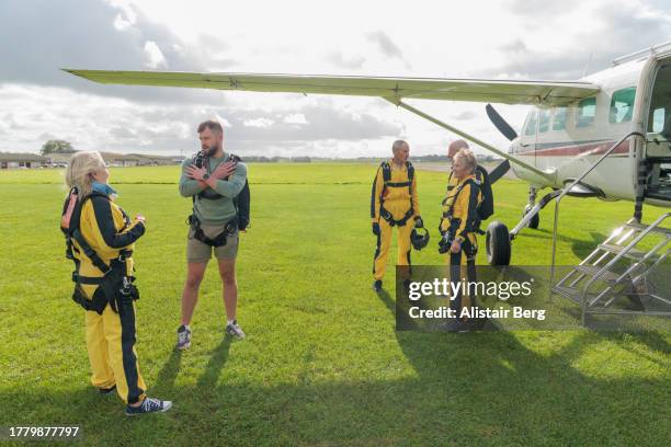 senior skydivers preparing  to enter the plane for their takeoff - thier stock pictures, royalty-free photos & images