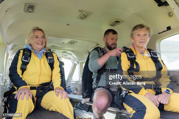 senior tandem skydivers making final preparation for their jump - adrenaline stress stock pictures, royalty-free photos & images