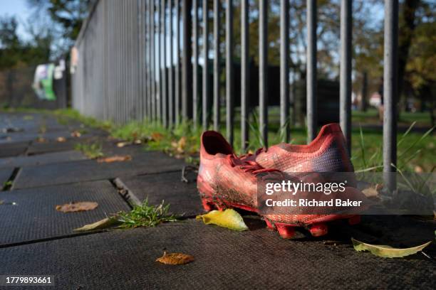 Pair of football boots fremain on the ground outside Ruskin Park, a public green space in Lambeth where youth teams play minor league matches at...