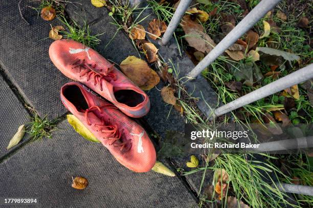 Pair of football boots fremain on the ground outside Ruskin Park, a public green space in Lambeth where youth teams play minor league matches at...