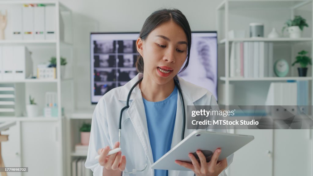 Young Asian female doctors looking at camera video call medical results during consultation to patient in hospital. Medical health care.
