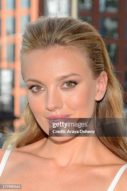 Actress Bar Paly poses in front of the billboard promoting the Blu-ray and DVD debut of "Pain & Gain" on the Sunset Strip on August 26, 2013 in West...