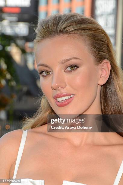 Actress Bar Paly poses in front of the billboard promoting the Blu-ray and DVD debut of "Pain & Gain" on the Sunset Strip on August 26, 2013 in West...