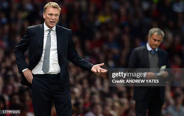 Manchester United's Scottish manager David Moyes gestures as Chelsea's Portuguese manager Jose Mourinho watches during the English Premier League...