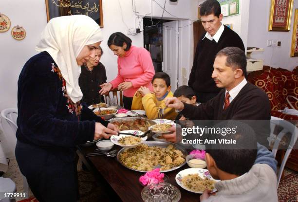 Palestinians gather for a meal on the second day of the Muslim holiday of Eid al-Adha, or feast of sacrifice, February 12, 2003 in the West Bank city...