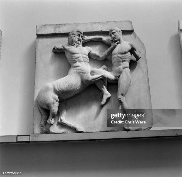 Carved marble plaque, one of the Parthenon Sculptures, showing a fight between a Lapith and a Centaur, on display at the British Museum in London,...